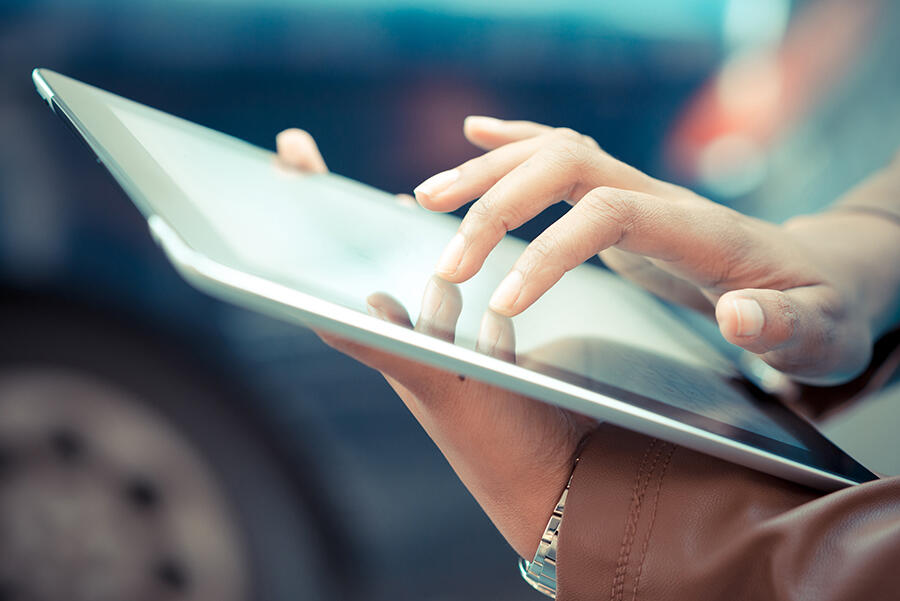 A person using a tablet, close up of their hands