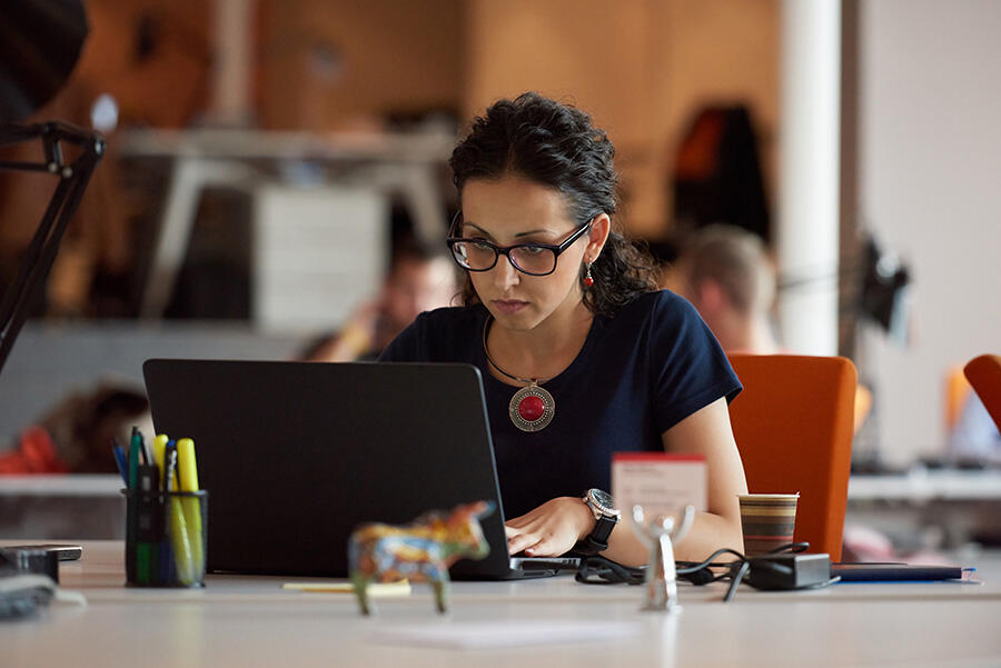 woman working on a laptop in an open workspace